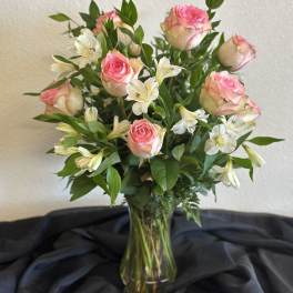 Pink roses and white alstroemeria in a clear glass vase
