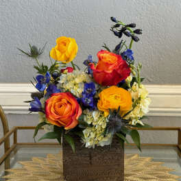 Colorful rose arrangement in a square wooden vase