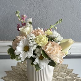 Pastel flower arrangement in a ribbed white vase