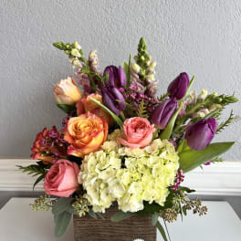 Mixed bouquet of roses, tulips, and hydrangeas in a wooden box