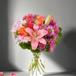 Pink and orange mixed bouquet in a clear glass vase