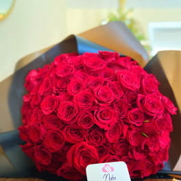 Large bouquet of red roses wrapped in dark paper