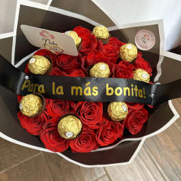 Bouquet of red roses with gold-wrapped chocolates and a black ribbon