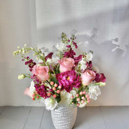 Pink and white floral arrangement in a textured white vase