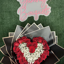 Heart-shaped red rose bouquet with white baby's breath and black wrapping