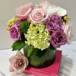 Pink and lavender roses with hydrangea in a glass vase