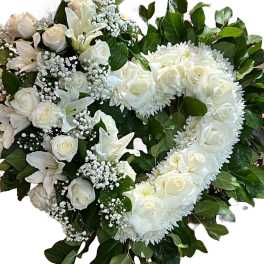 Heart-shaped white floral arrangement with roses and lilies