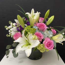 Pink roses and white lilies arranged in a black vase