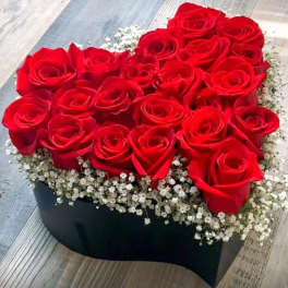 Heart-shaped box filled with red roses and white baby's breath
