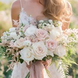 Bride holding a bouquet of pale pink and white roses