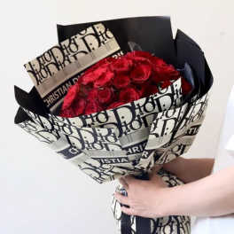 Bouquet of red roses wrapped in black-and-white Dior paper