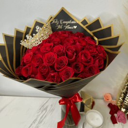 Bouquet of red roses with a jeweled crown and black-and-gold wrapping