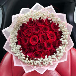 Bouquet of red roses with white baby's breath in pink wrapping