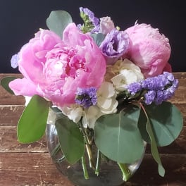 Pink and lavender flowers arranged in a clear glass vase