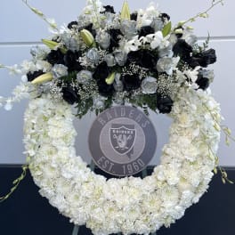 Large black, white, and silver floral wreath on an easel