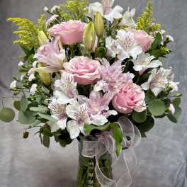 Pink and white bouquet in a glass vase with a ribbon