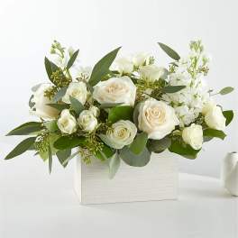 White roses and white blooms arranged in a white rectangular box