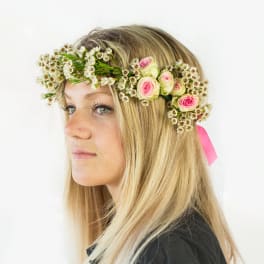 Woman wearing a floral crown with pink roses and small white flowers