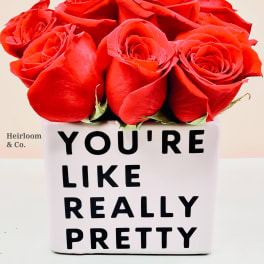 Red roses in a white box with bold black text