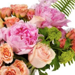 Pastel bouquet with pink peonies and peach roses accented by fern fronds