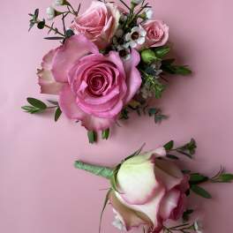Pink rose bouquet and matching boutonniere on a pink background