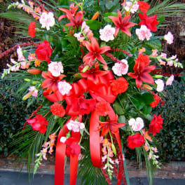 Large red and pink floral standing spray with ribbon