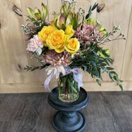 Bouquet of yellow roses and pink chrysanthemums in a glass vase