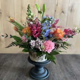 Colorful mixed flower arrangement in a pedestal vase