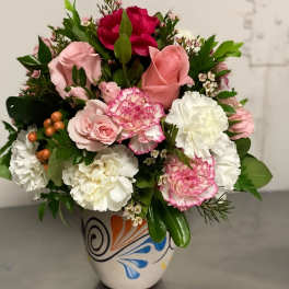 Pink and white mixed flower arrangement in a painted ceramic vase