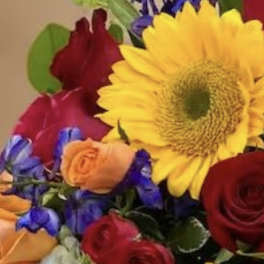 Mixed bouquet with a large yellow sunflower and red roses