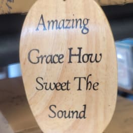 Oval wooden hanging sign with the words "Amazing Grace"
