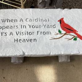White memorial plaque with a red cardinal and engraved text
