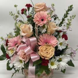 Mixed pink and white flower basket with a pink ribbon