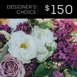 Close-up bouquet of white ranunculus, lavender roses, and purple lilacs