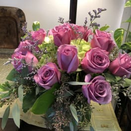 Bouquet of pink and lavender roses with pale green hydrangeas in a vase