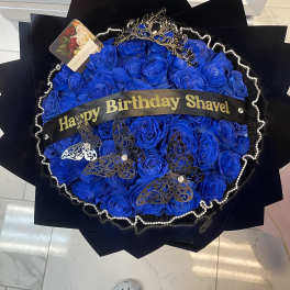 Blue rose bouquet with a birthday ribbon and decorative butterflies