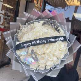 Bouquet of white roses with crowns and a birthday ribbon