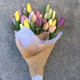 Bouquet of multicolored tulips wrapped in brown paper
