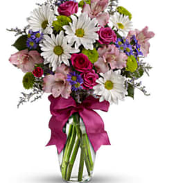 Bouquet of daisies, roses, and pink lilies in a glass vase