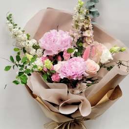 Pink and white mixed bouquet wrapped in brown paper