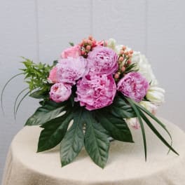 Pink peonies and white flowers arranged in a low bouquet
