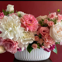 Pink and white floral arrangement in a white ribbed vase
