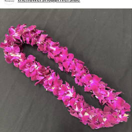 Two magenta orchid leis on a dark background