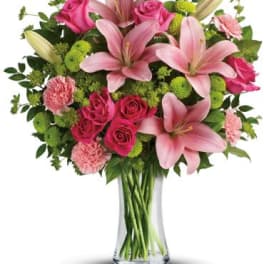 Pink lilies and roses in a clear glass vase