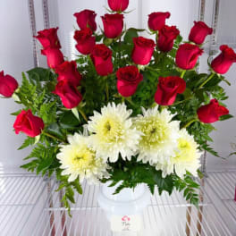 Red roses and white chrysanthemums arranged in a white vase