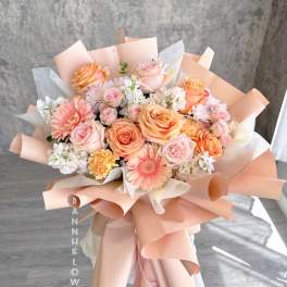 Peach and pink mixed bouquet with roses and daisies wrapped in blush paper