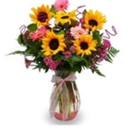 Bouquet of sunflowers and pink flowers in a glass vase