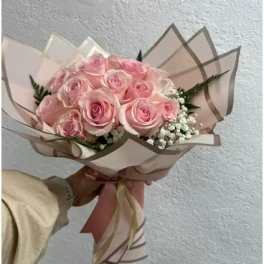 Bouquet of pale pink roses wrapped in blush paper