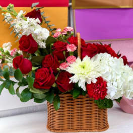 Basket arrangement of red roses, white hydrangeas, and white chrysanthemums
