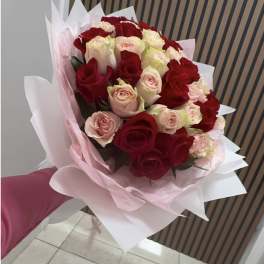 Bouquet of red and blush roses wrapped in pink paper